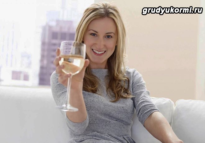 Girl sitting on the sofa and holding a glass of white wine