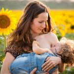 Молодая мама с малышом в поле подсолнечника