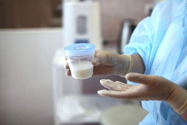 doctor holding a jar of breast milk